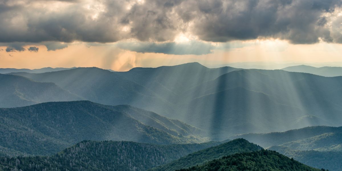 Light beams shining through storm clouds onto the Blue Ridge Mountains. Taken from Mount Craig.