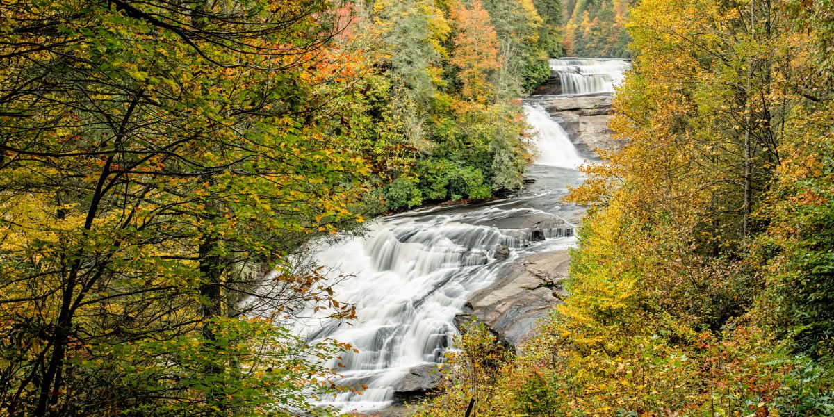 Series of three waterfalls surrounded by bright fall foliage.