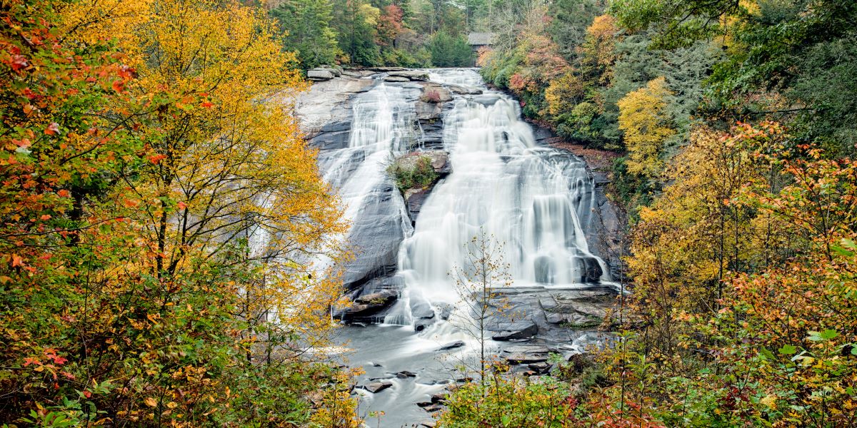 Large waterfall surrounded by bright fall foliage.